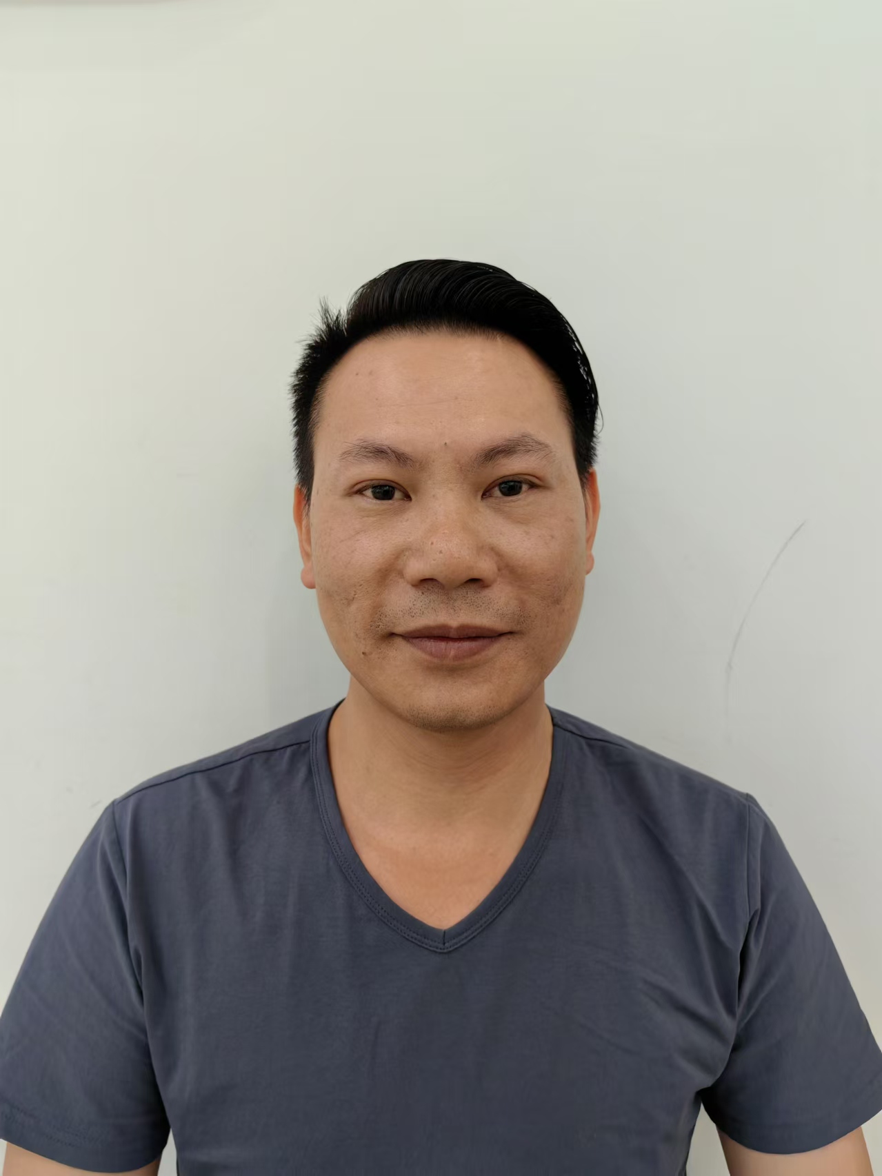 三十五岁左右男性设计师头像，穿着深色休闲西装，专业表情，背景简洁明亮